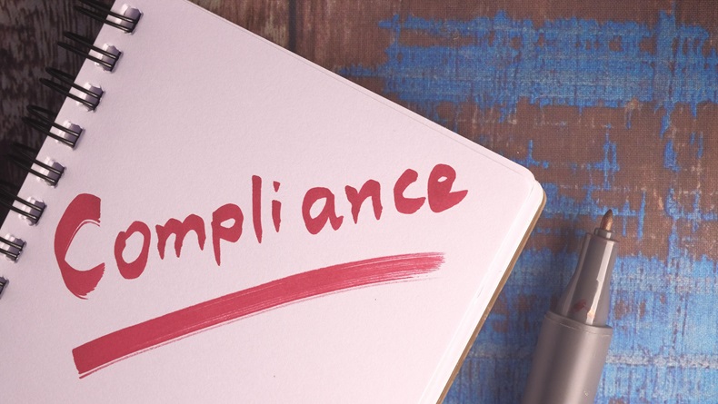 The word compliance on a notebook.