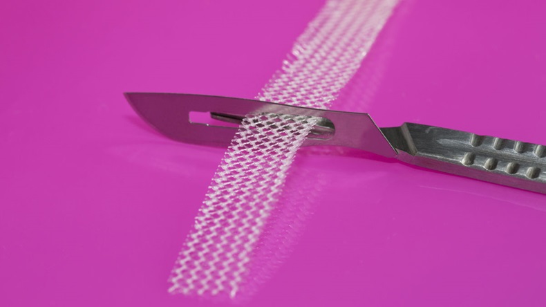 Surgical knife and tension-free vaginal tape on pink background - Image
