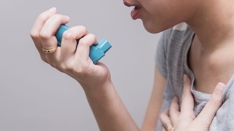 Asian woman using a pressurized cartridge inhaler extended pharynx, Bronchodilator