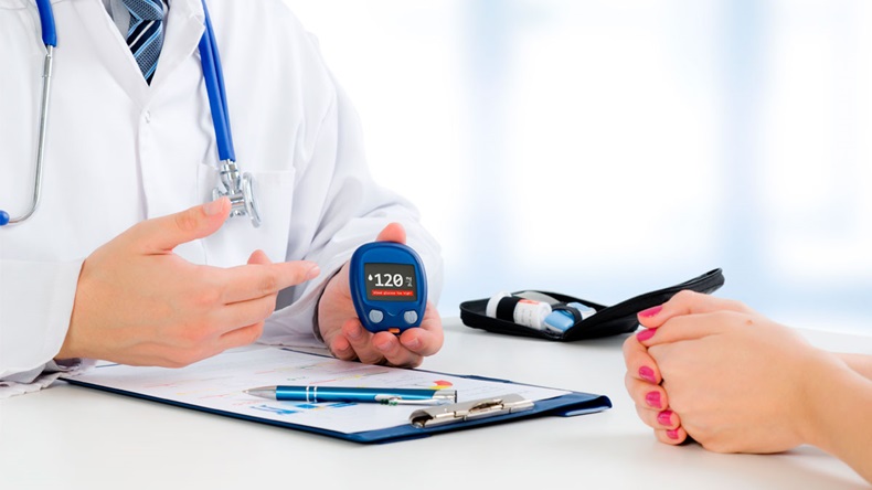 Doctor shows glucometer with glucose level. doctor patient diabetes glucometer blood glucose office hand concept