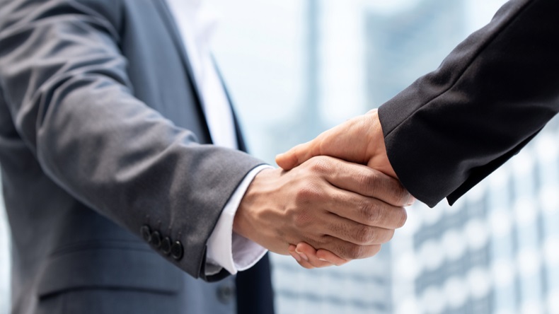 Businessmen making handshake outdoors in city office building background for merger and acquisition concept - Image 