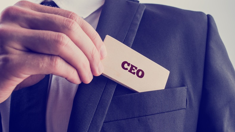  Retro style image of a businessman showing a wooden card reading - CEO - as he withdraws it from the pocket of his suit jacket. - Image 