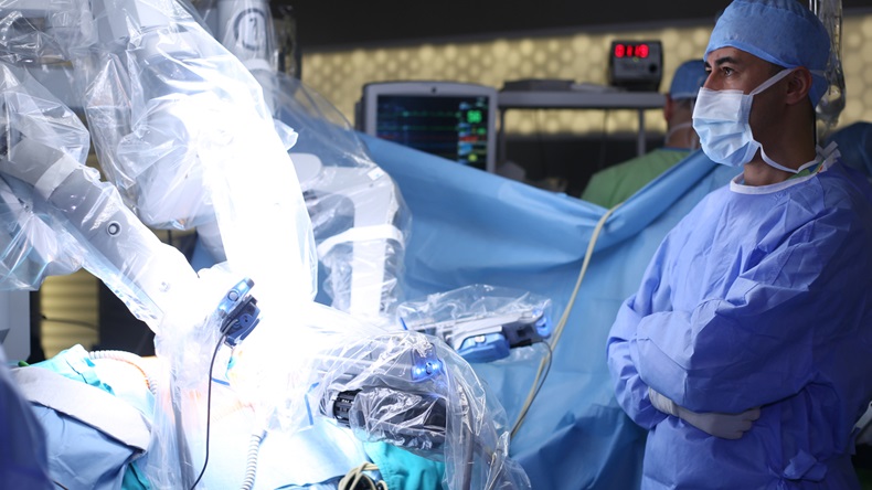 Medical robot. Medical operation involving robot. Robotic Surgery. Manipulators performing surgery on a man - Stock Image