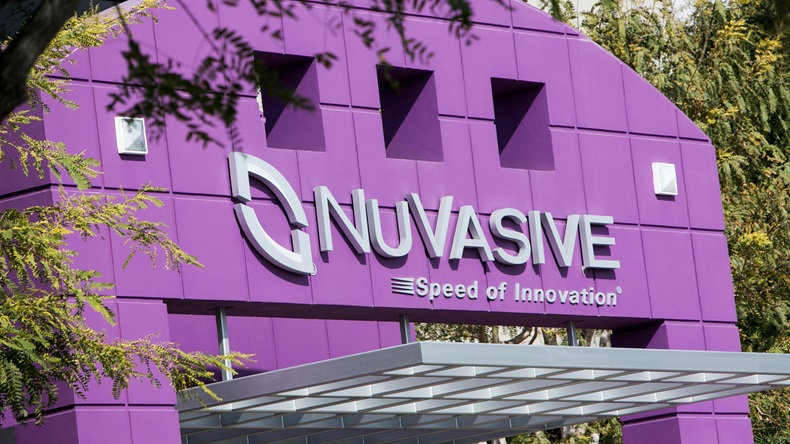 A logo sign outside of the headquarters of NuVasive, Inc.