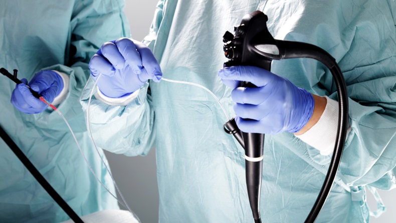 Doctor holding endoscope before gastroscopy.