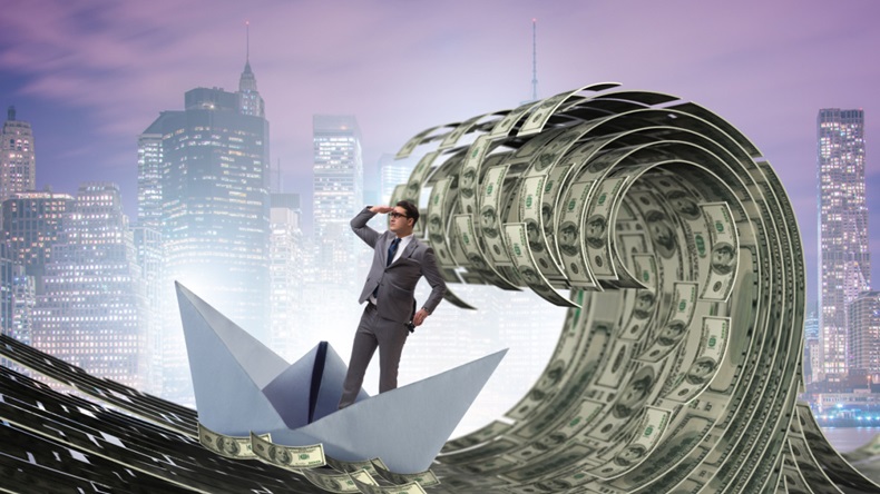 Businessman riding paper boat in sea of money
