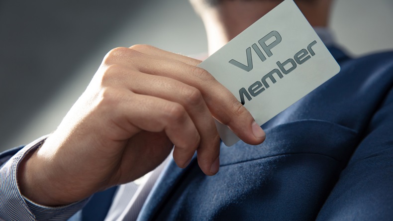 Businessman holding card that says "VIP Member."
