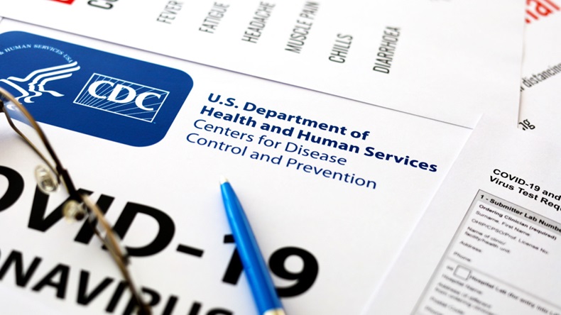 Paperwork with the CDC logo and COVID-19 printed on it.