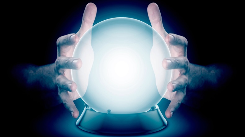 Hands around a crystal ball against a dark background.