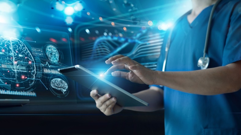 Physician holding tablet in front of brain scan imagery.