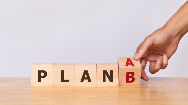 Hand flip wooden cube with the word PLAN A to PLAN B on white background. Business concept